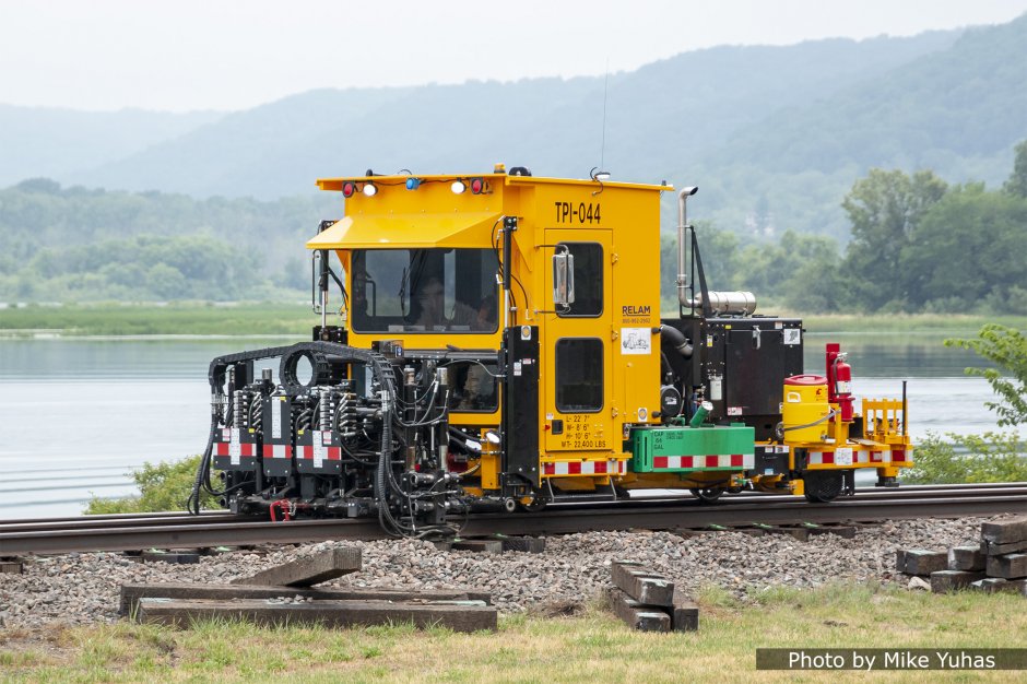 The tie plate inserter raises the rails and slides the tie plates into position, and lowers the rails onto the tie plates. Racine Railroad Products developed its first tie plate inserters in the early 2000s; this, the Advanced Tie Plate Inserter (ATPI) was introduced in 2017. 