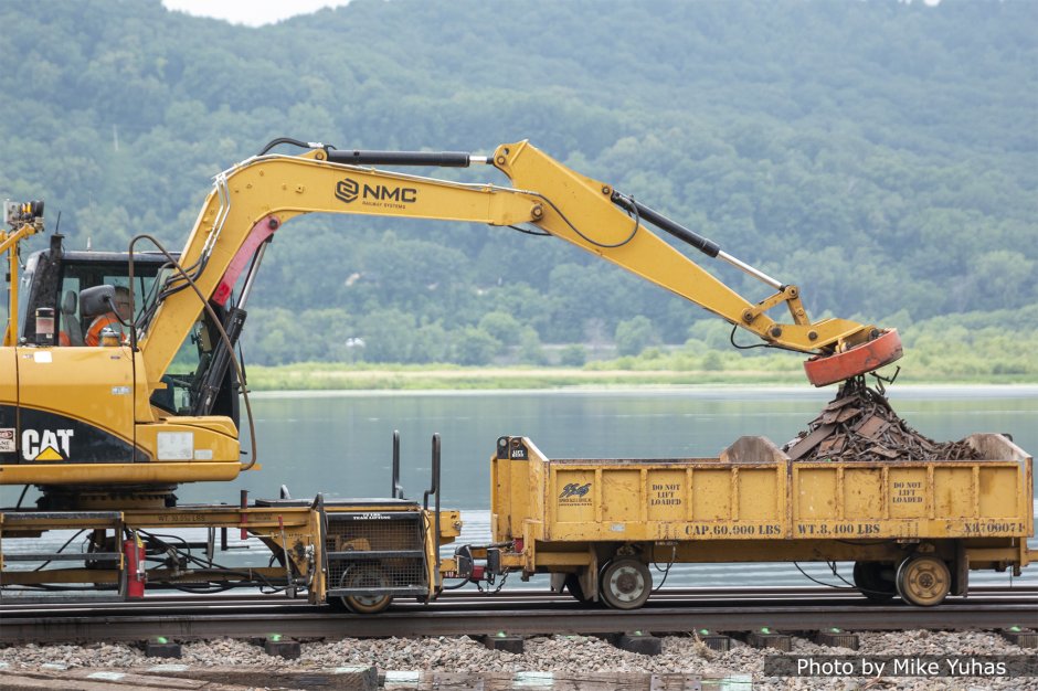 Used “OTM” (on track material) is picked up with an electromagnet and transported off the job site for recycling.     Now that the ties are secured to the rail by spikes and anchors, the remaining machines in the gang concentrate on track surfacing.   